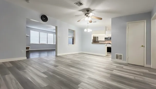 a view of a yard in front of a house with plants and large tree