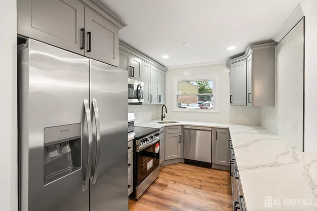 a kitchen with stainless steel appliances granite countertop a refrigerator and a sink