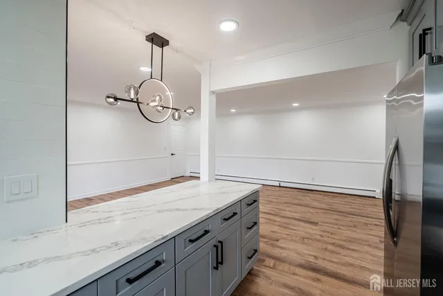 a bathroom with a granite countertop sink a mirror and shower