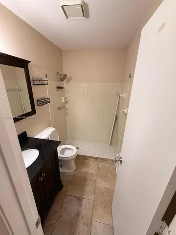 a bathroom with a granite countertop sink toilet and shower