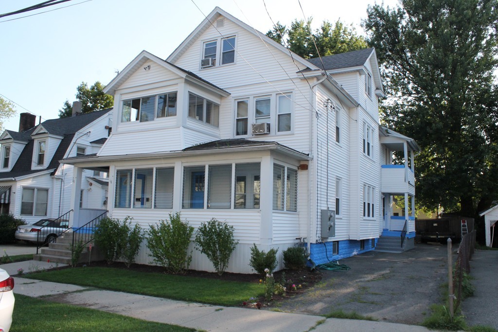 a front view of a house with a yard and trees