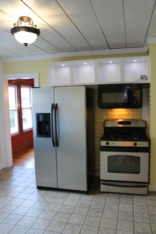 18-20 Howes Street Springfield, MA 01118 - Photo 5 of 30 a kitchen with stainless steel appliances granite countertop a stove a microwave and a refrigerator