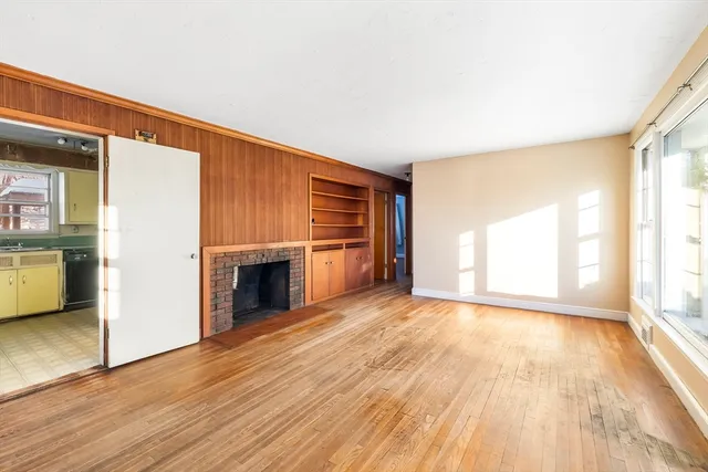 wooden floor fireplace and windows in an empty room