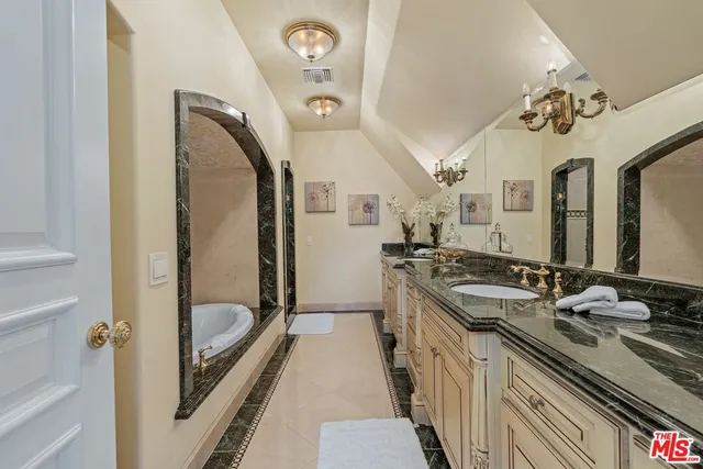 a bathroom with a granite countertop sink a mirror and a shower