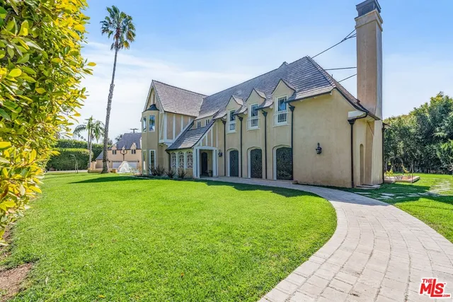 a view of a house with backyard and sitting area