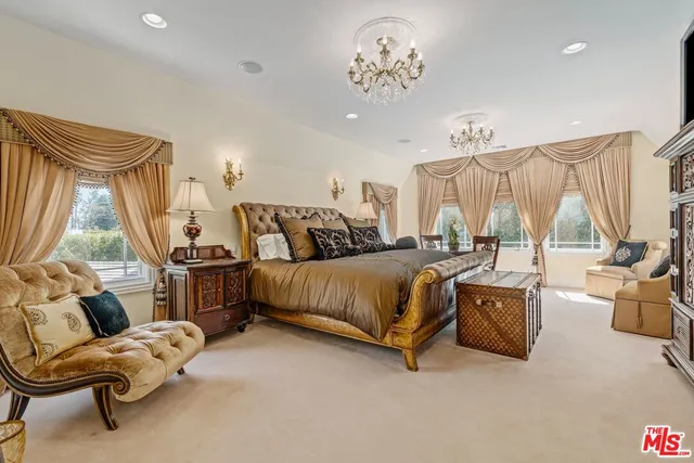 a bedroom with furniture and a large window