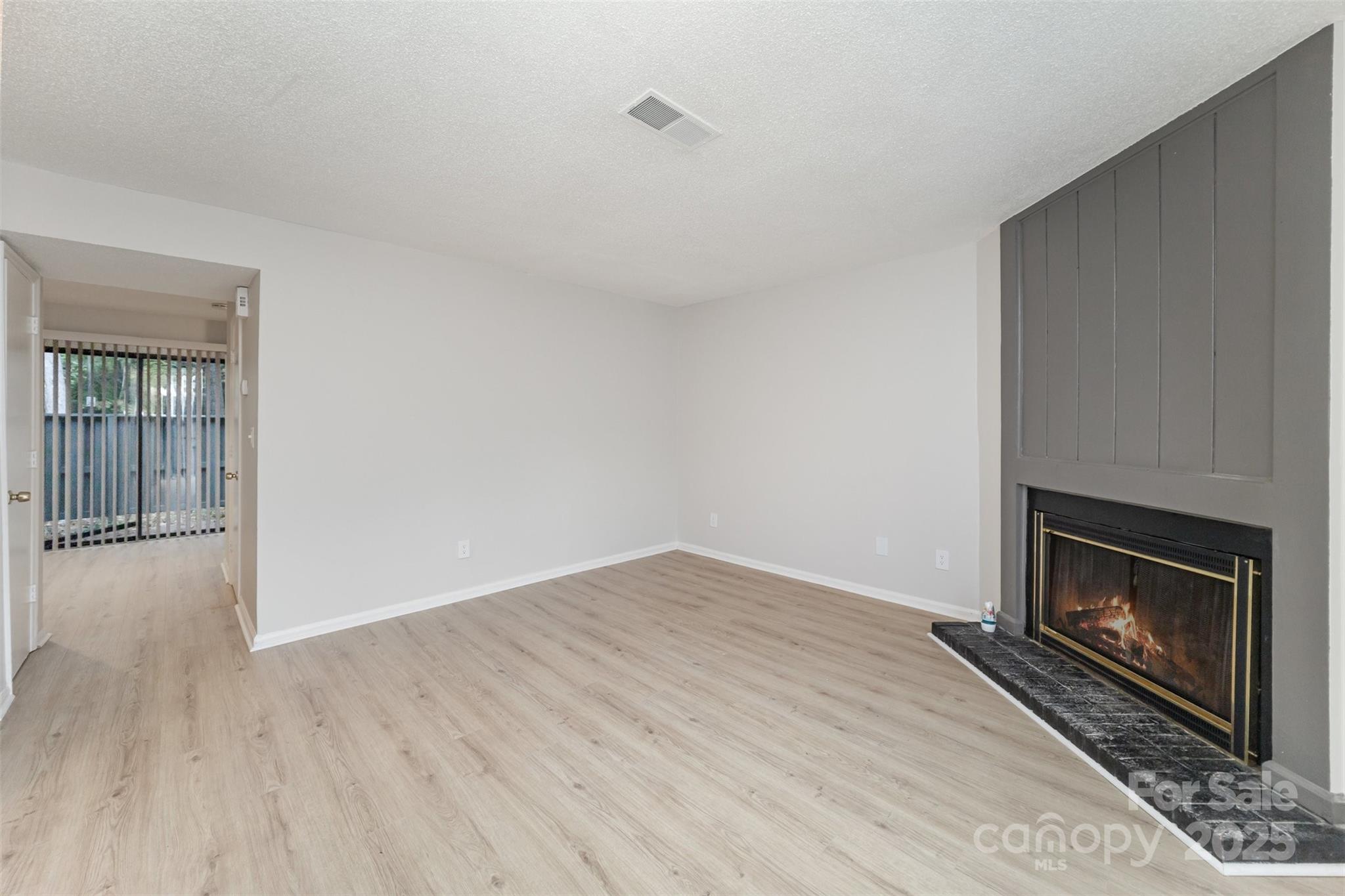 6128 Bent Tree Court Charlotte, NC 28212 - Photo 2 of 16 a view of empty room with wooden floor and fireplace