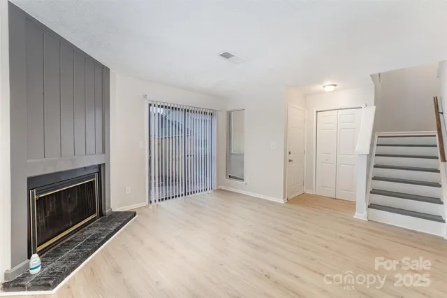 a view of empty room with wooden floor and fireplace
