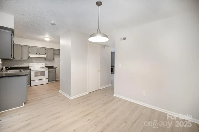 a kitchen with stainless steel appliances granite countertop a sink a stove a refrigerator and cabinets