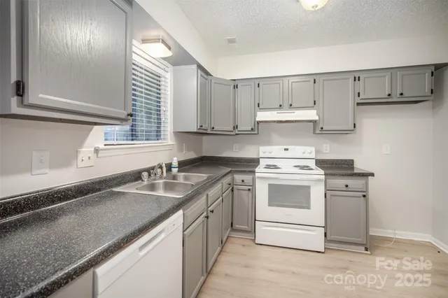 a kitchen with stainless steel appliances granite countertop a sink stove and cabinets