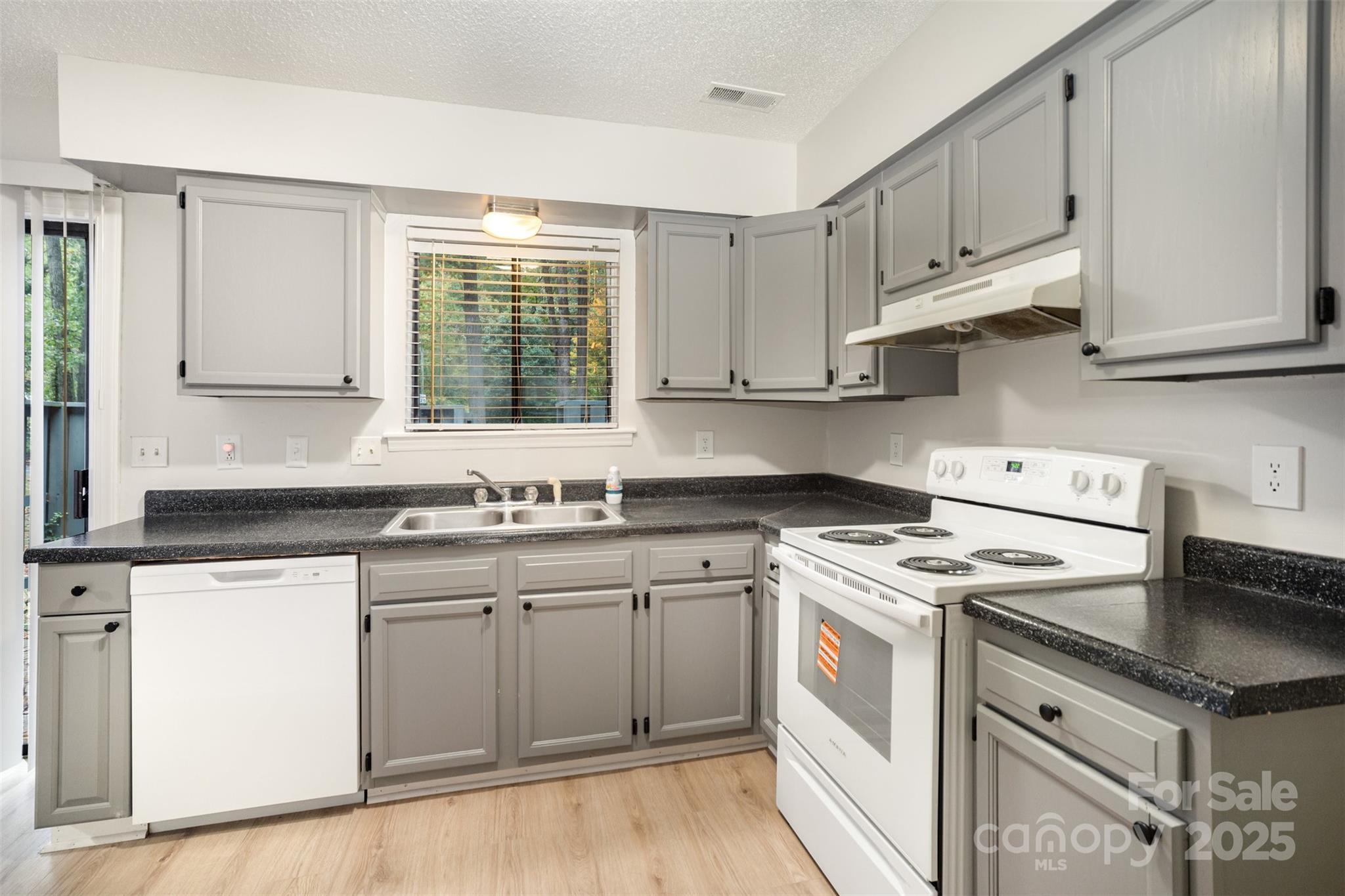 6128 Bent Tree Court Charlotte, NC 28212 - Photo 8 of 16 a kitchen with granite countertop white cabinets and white appliances