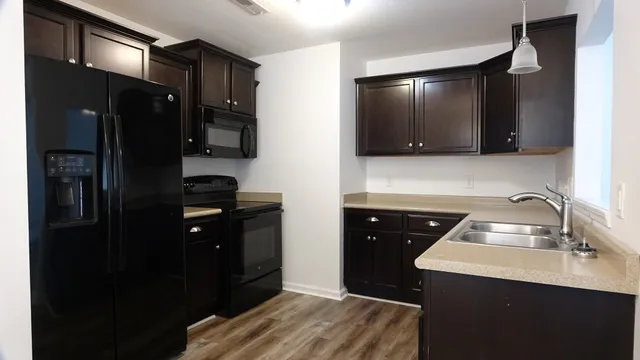 a view of a room with wooden floor cabinet and chandelier