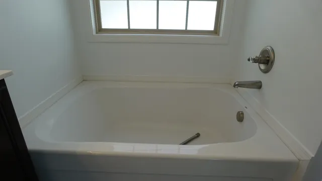 a bathroom with a sink double vanity mirror and a bathtub