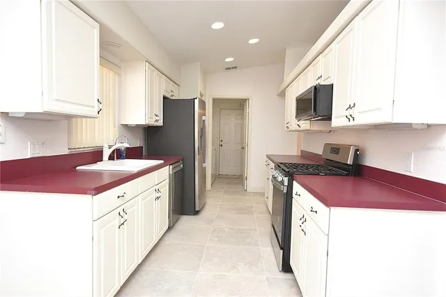 a kitchen with stainless steel appliances kitchen island granite countertop a sink and cabinets