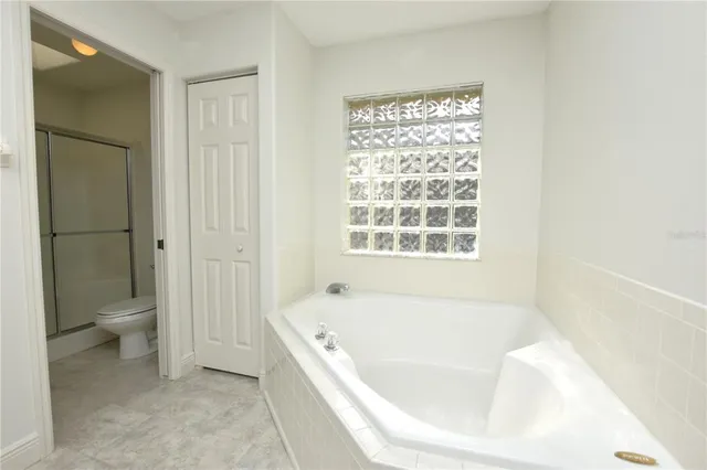 a white bath tub sitting next to a toilet