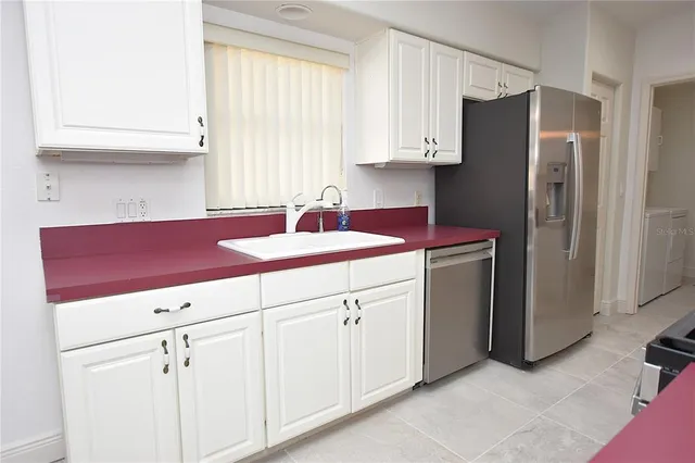 a kitchen with white cabinets and a refrigerator