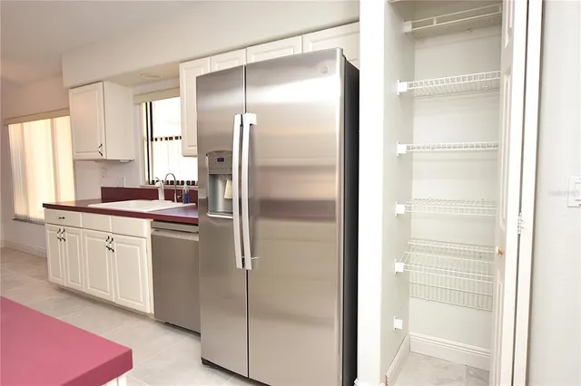 a kitchen with a refrigerator and white cabinets