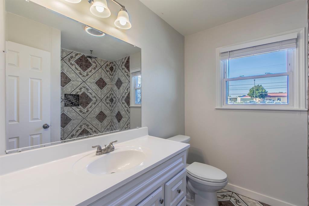 1029 North New Road Waco, TX 76710 - Photo 11 of 26 a bathroom with a granite countertop sink mirror vanity and toilet