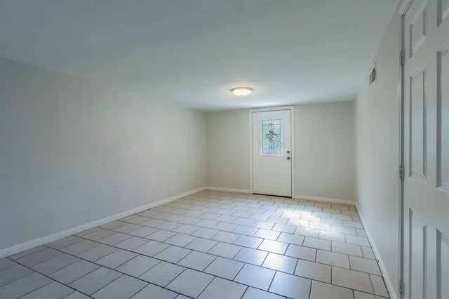 an empty room with white wall and tiles