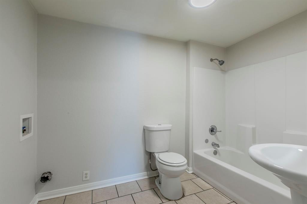 1029 North New Road Waco, TX 76710 - Photo 19 of 26 a bathroom with a toilet a sink and bathtub