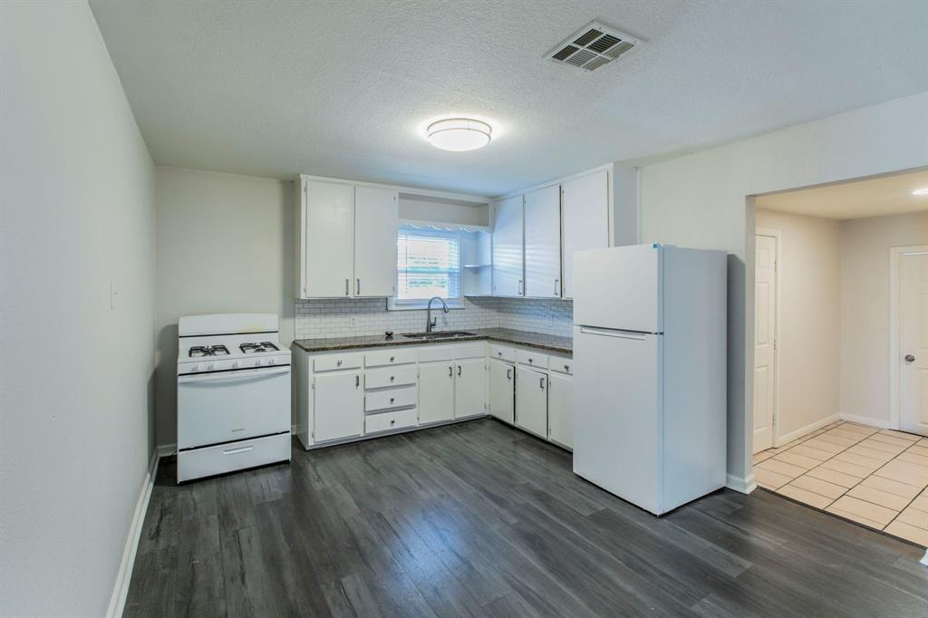 1029 North New Road Waco, TX 76710 - Photo 6 of 26 a kitchen with a white cabinets and wooden floor