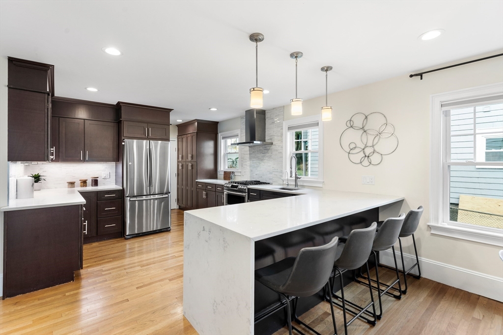 47 Fuller Road, Unit 47 Watertown, MA 02472 - Photo 3 of 21 a kitchen with stainless steel appliances a dining table chairs stove and refrigerator