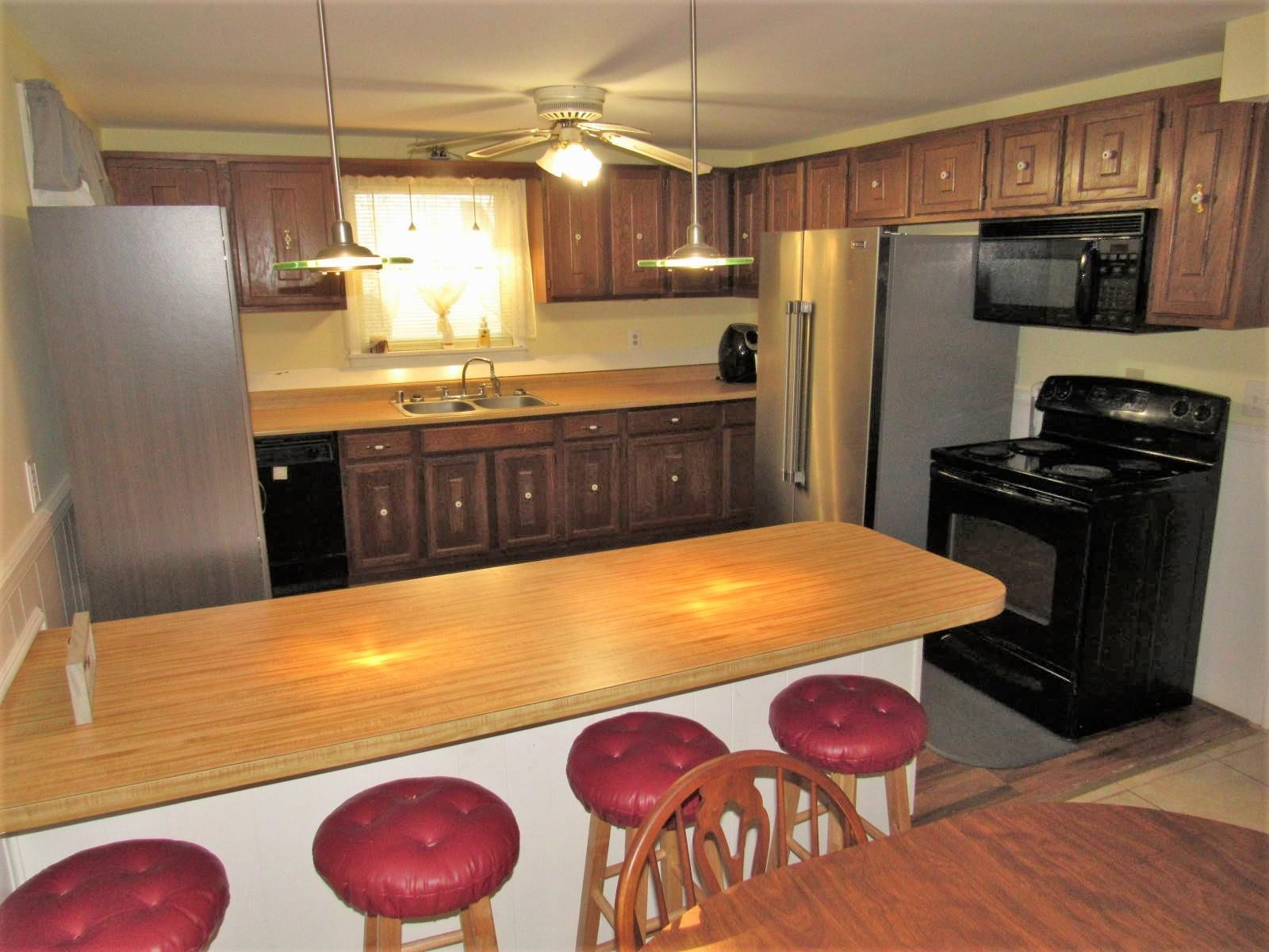 306 Waters Edge Loop Henderson, NC 27537 - Photo 14 of 35 a kitchen with stainless steel appliances a dining table chairs refrigerator and stove