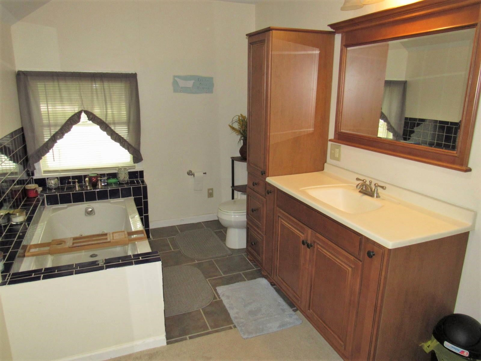 306 Waters Edge Loop Henderson, NC 27537 - Photo 24 of 35 a bathroom with a sink and a mirror