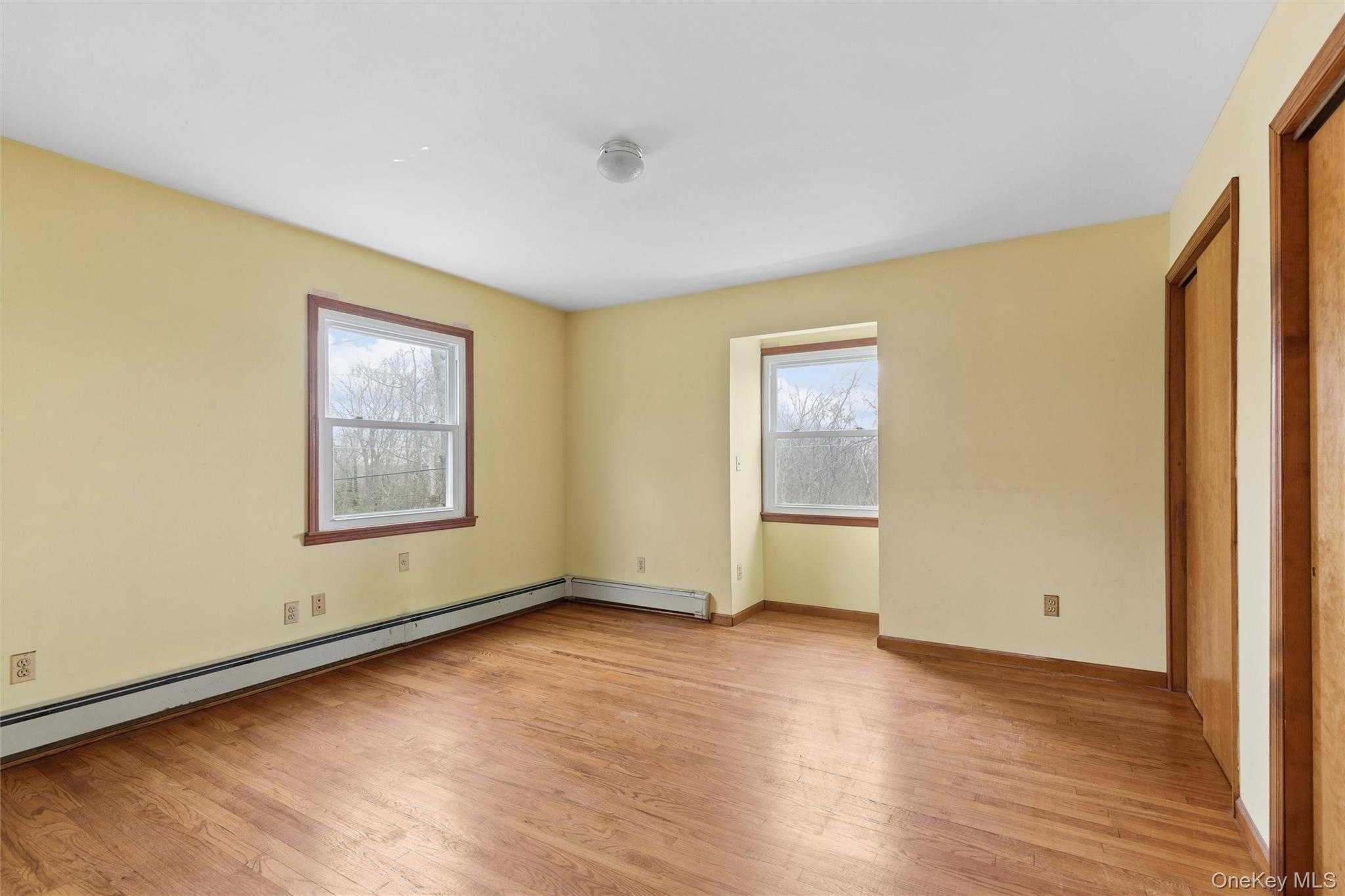 49 Overhill Road Wading River, NY 11792 - Photo 19 of 27 an empty room with wooden floor and windows