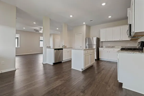 an open kitchen with white cabinets and stainless steel appliances