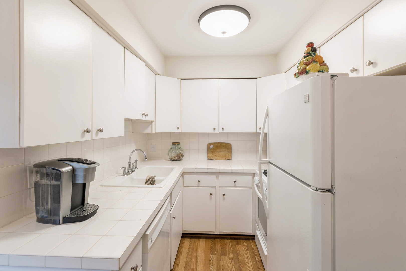 258 Inverrary Lane Deerfield, IL 60015 - Photo 4 of 13 a kitchen with a refrigerator a stove and white cabinets