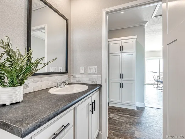 a bathroom with a granite countertop sink and a mirror