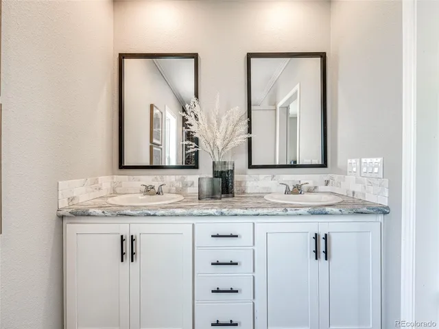 a bathroom with double sink and a mirror