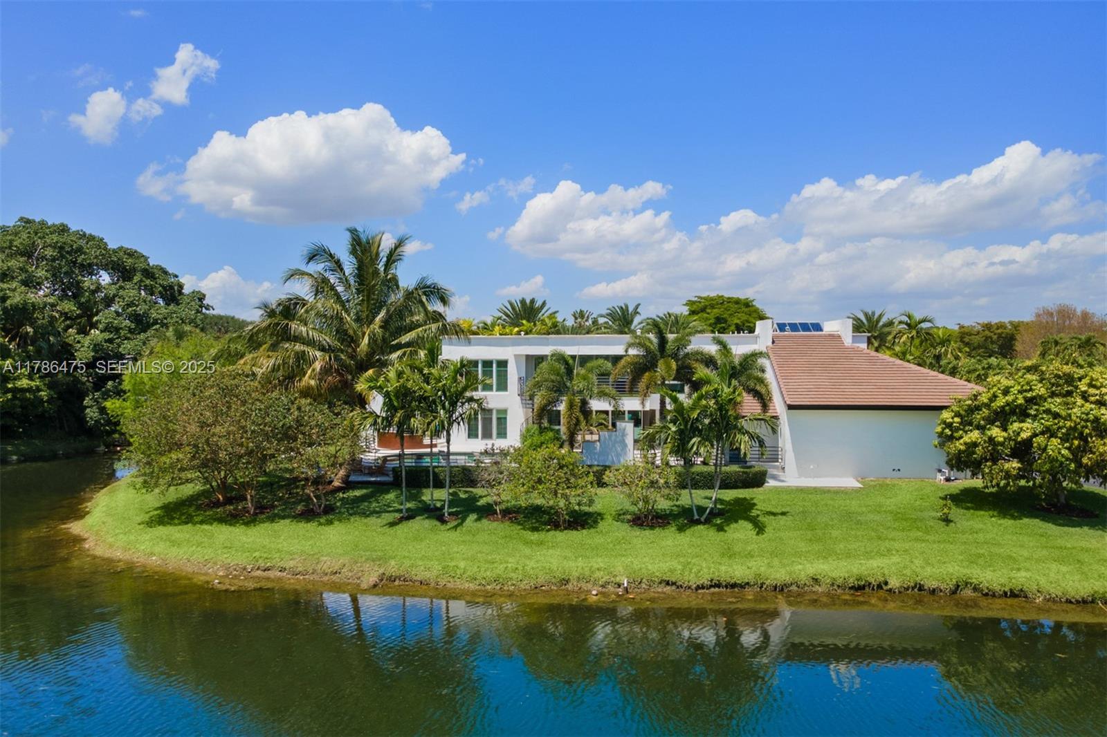 a view of a house with a yard and a pond