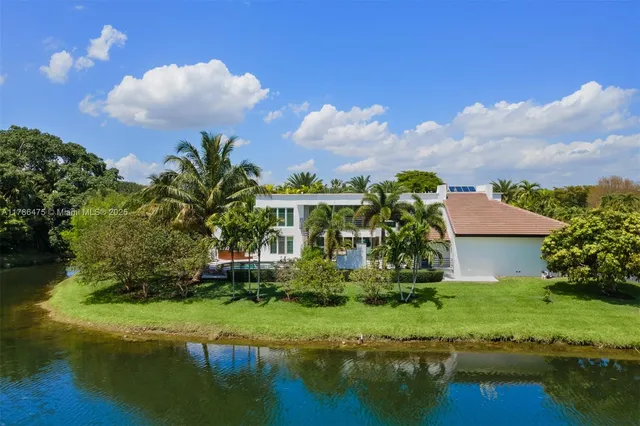 a view of a house with a yard and a pond