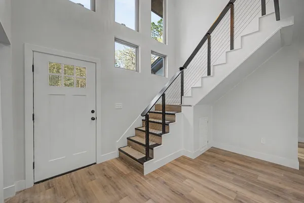 a view of an empty room and chandelier fan