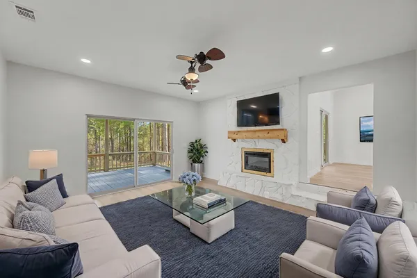 an empty room with wooden floor and a ceiling fan