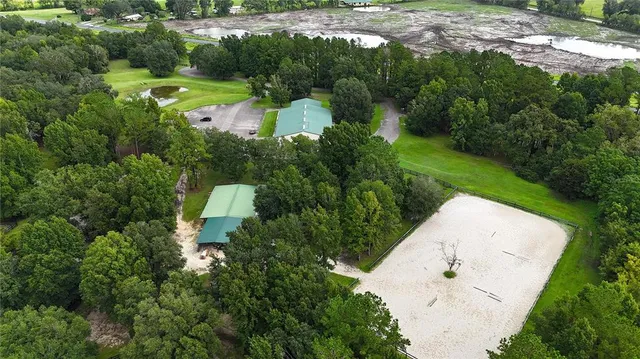 an aerial view of lake residential house with outdoor space and trees all around