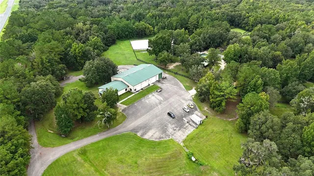 an aerial view of a house with a yard and trees