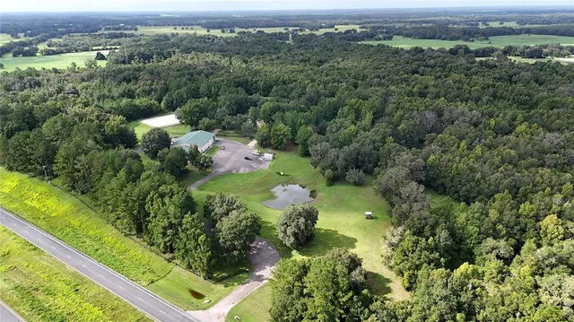 an aerial view of residential houses with outdoor space and trees