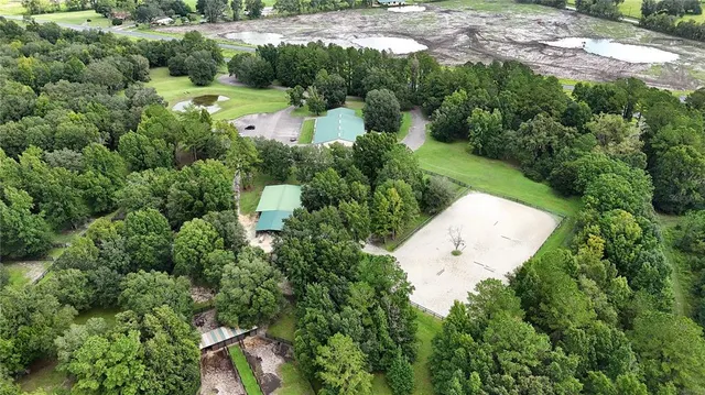 an aerial view of residential houses with outdoor space and trees