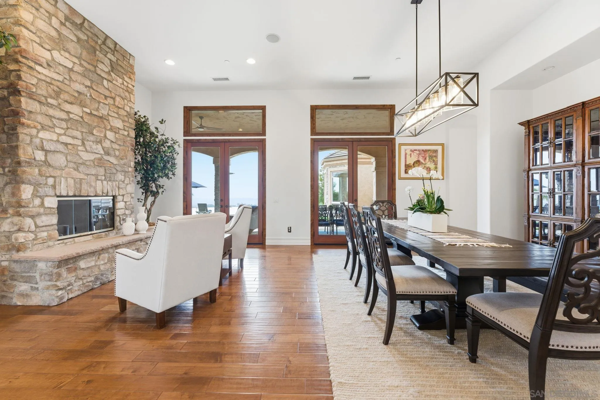 15480 Eastvale Road Poway, CA 92064 - Photo 50 of 71 a living room with couches a fireplace and kitchen view with wooden floor