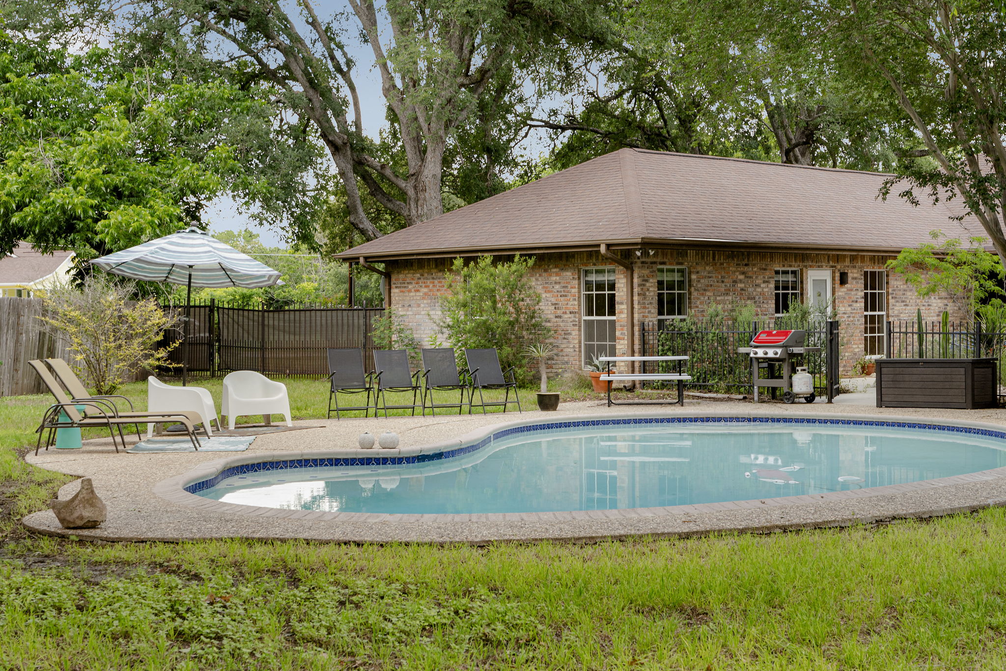 400 Hackberry Street Lockhart, TX 78644 - Photo 4 of 40 An inviting backyard oasis awaits with a sparkling inground pool and brick home.