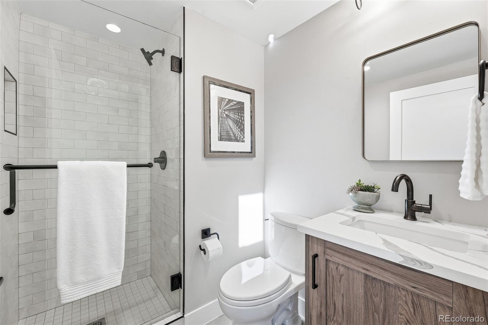 2186 South Sherman Street Denver, CO 80210 - Photo 36 of 44 a bathroom with a granite countertop toilet sink and shower