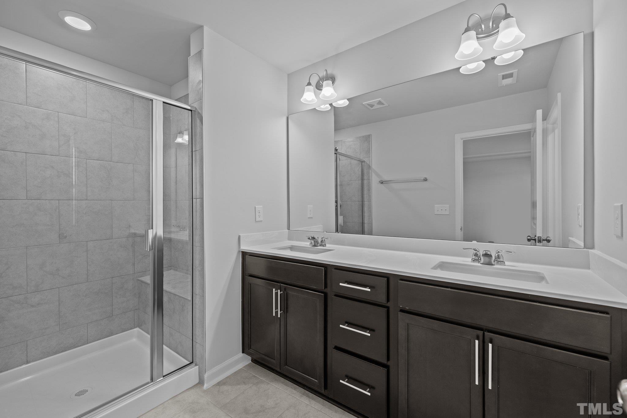 5106 Anamosa Street Raleigh, NC 27610 - Photo 15 of 49 a bathroom with a double vanity sink mirror and shower