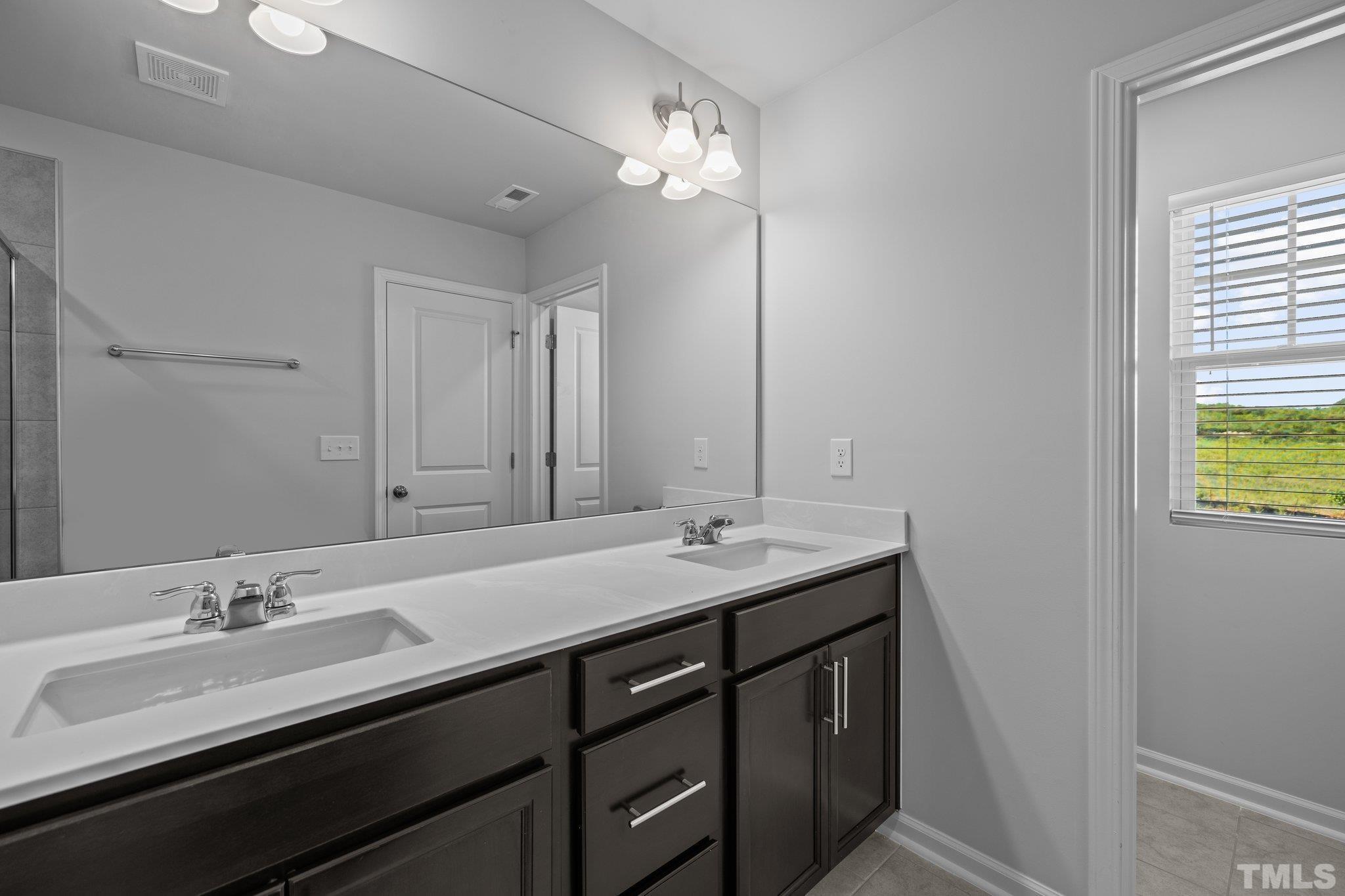 5106 Anamosa Street Raleigh, NC 27610 - Photo 16 of 49 a bathroom with a sink double vanity and a mirror