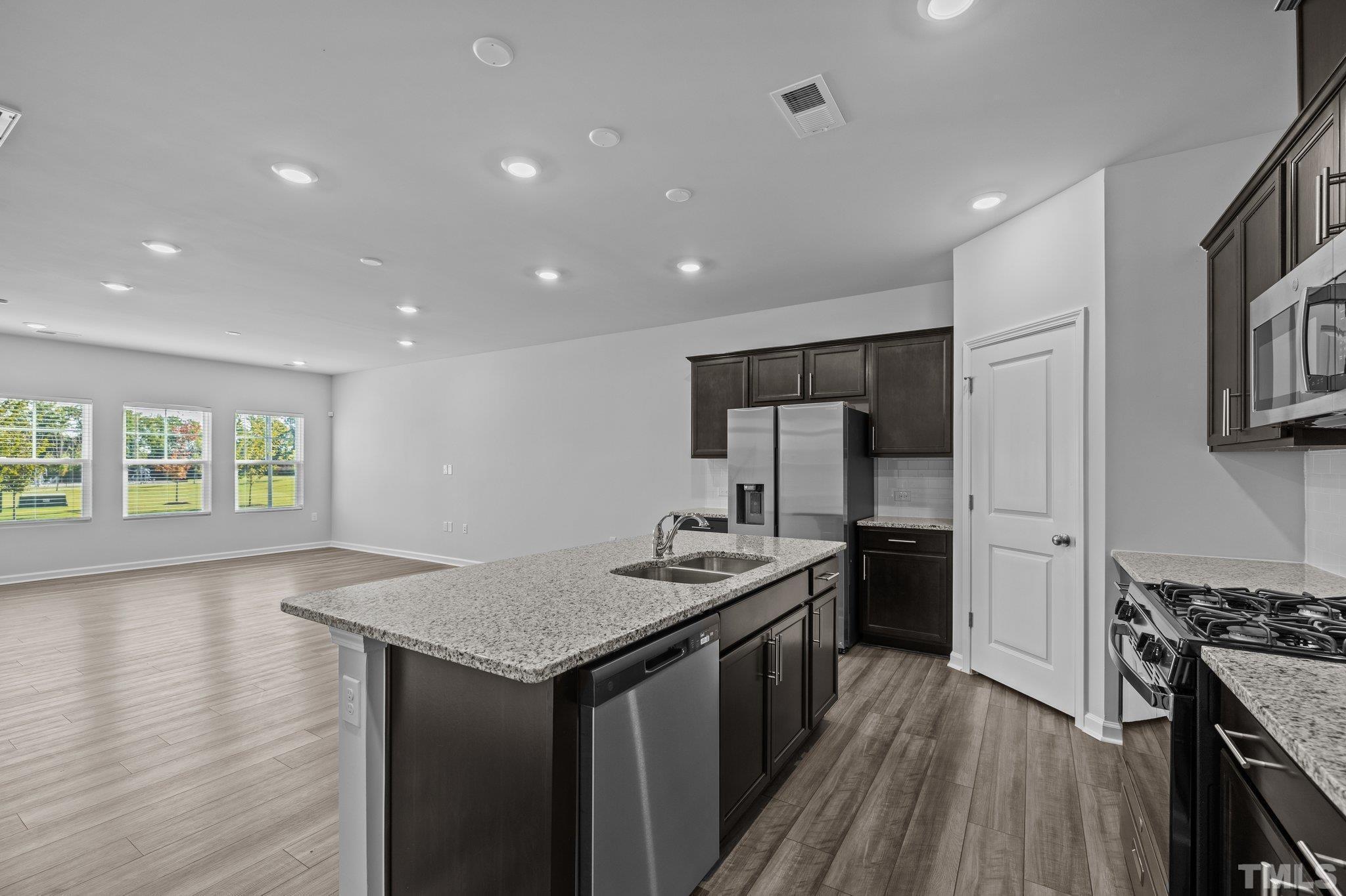 5106 Anamosa Street Raleigh, NC 27610 - Photo 22 of 49 a kitchen with a sink stove and refrigerator