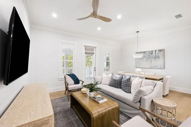 a living room with furniture flat screen tv and a large window