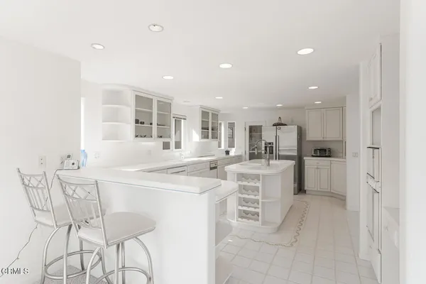 a large white kitchen with a sink and dishwasher