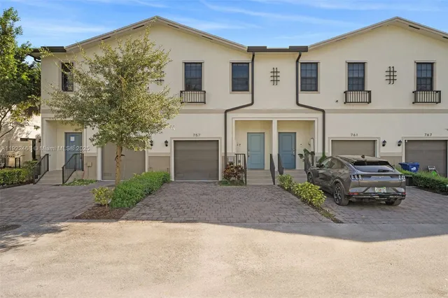 a car parked in front of a white house